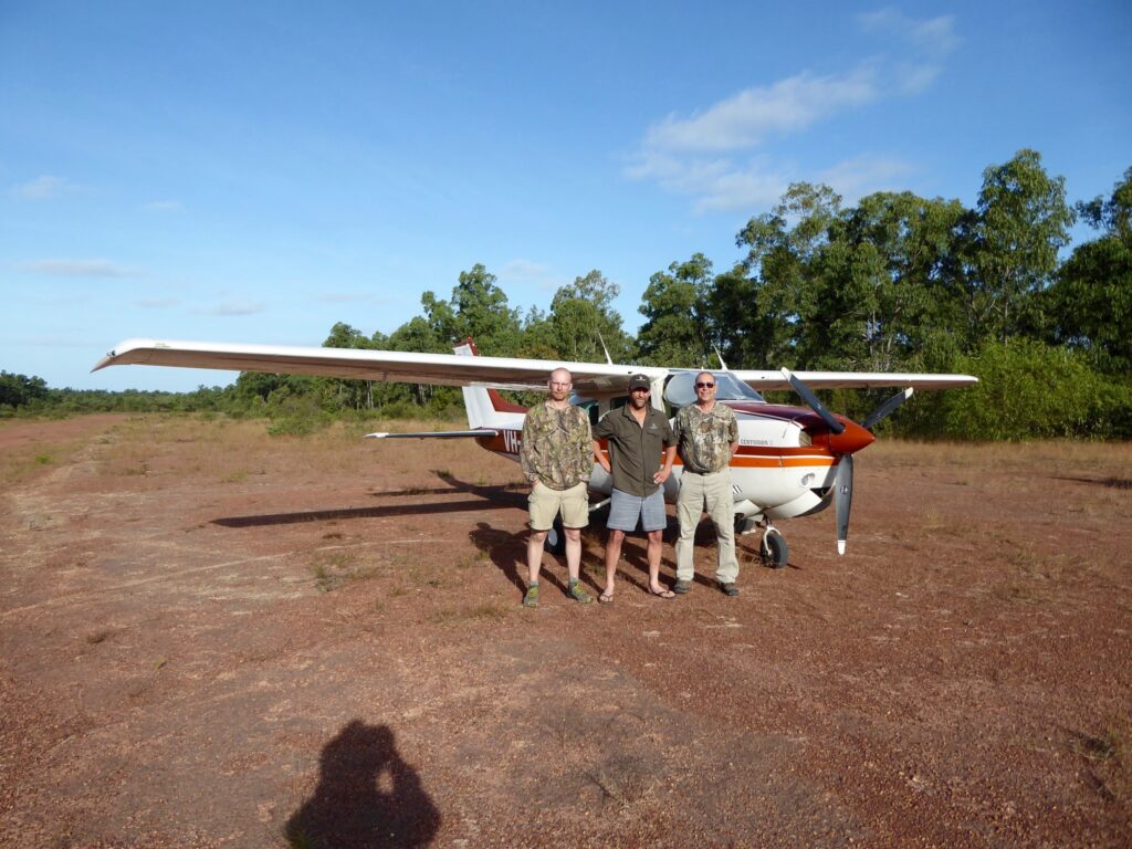 Hunters beside the charter plane on a bush airstrip