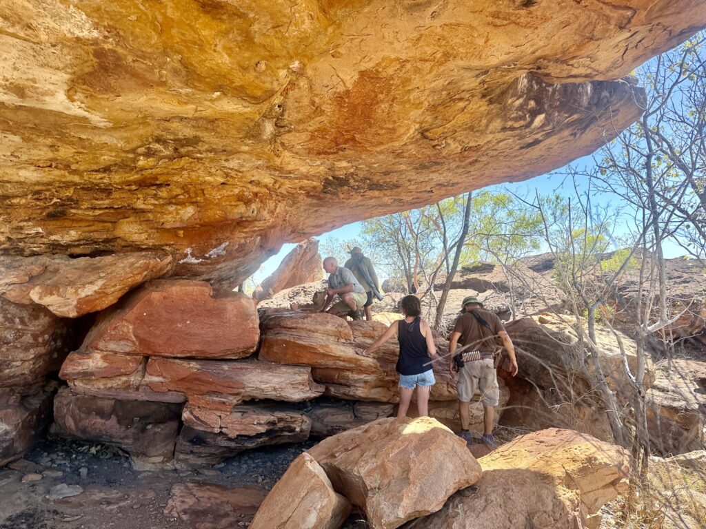 Hunters under a sandstone overhang on the escarpment