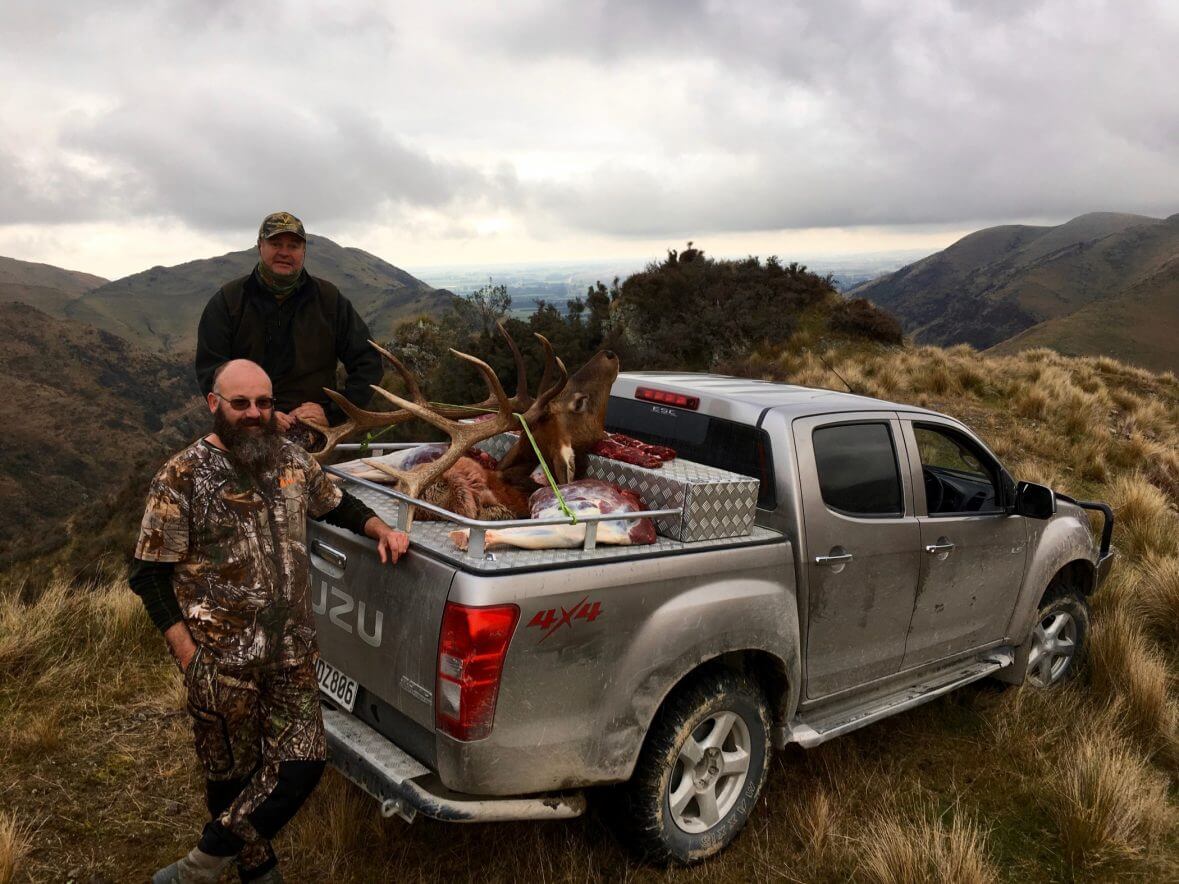 elk hunters with trophy on truck