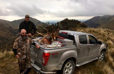 elk hunters with trophy on truck